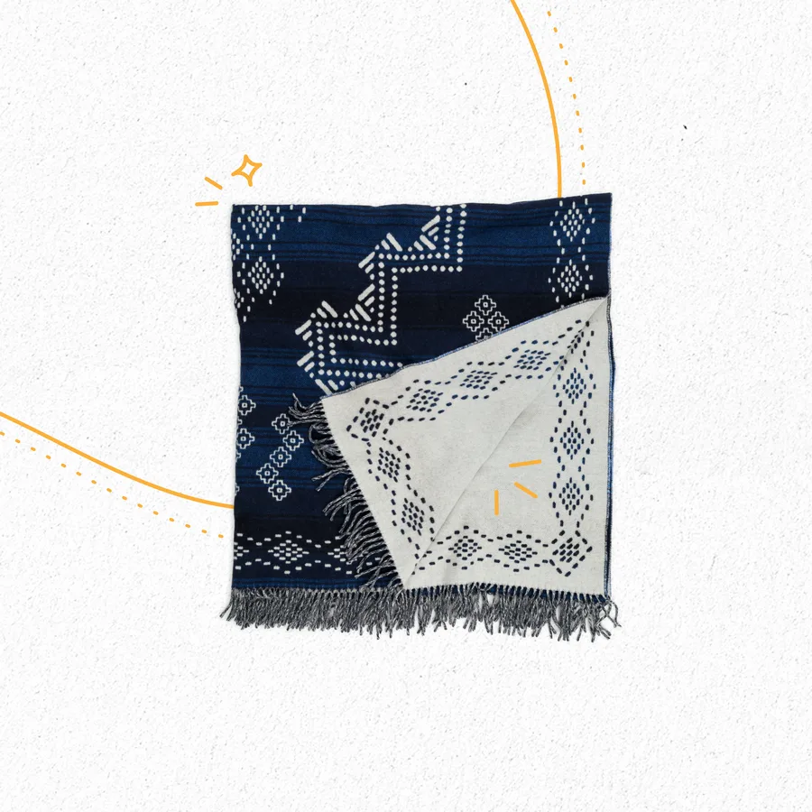 Deux bandanas indigo pliés, sous un trait d’étincelles orange.