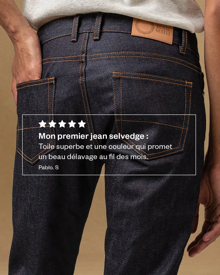 Avis client cinq étoiles posé sur un gros plan du denim.