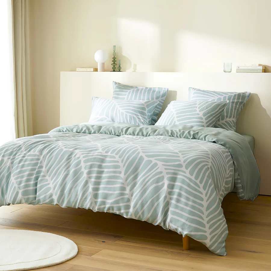 Chambre habillée du motif Dunes en vert d’eau, tapis et parquet.