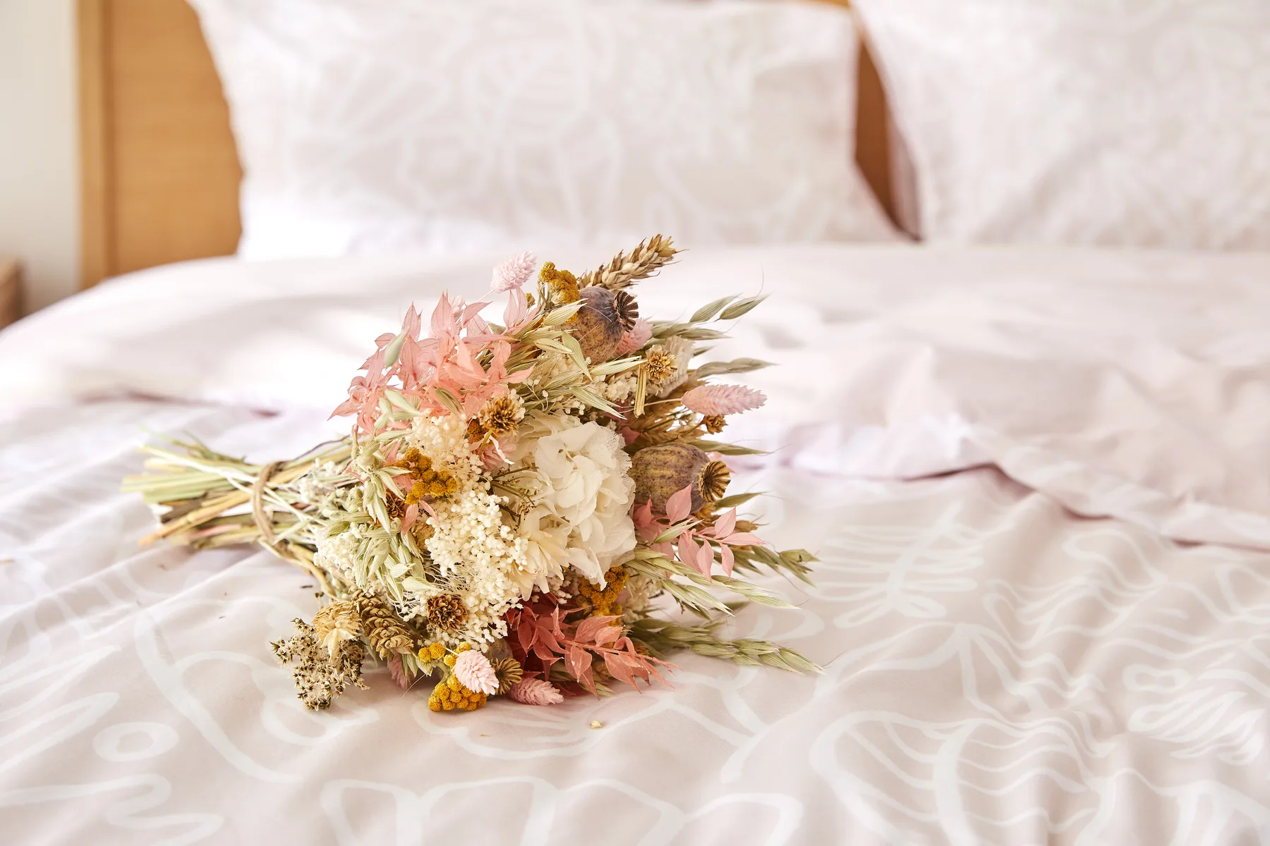 Bouquet de fleurs séchées posé sur la parure Flowrette rose poudré.
