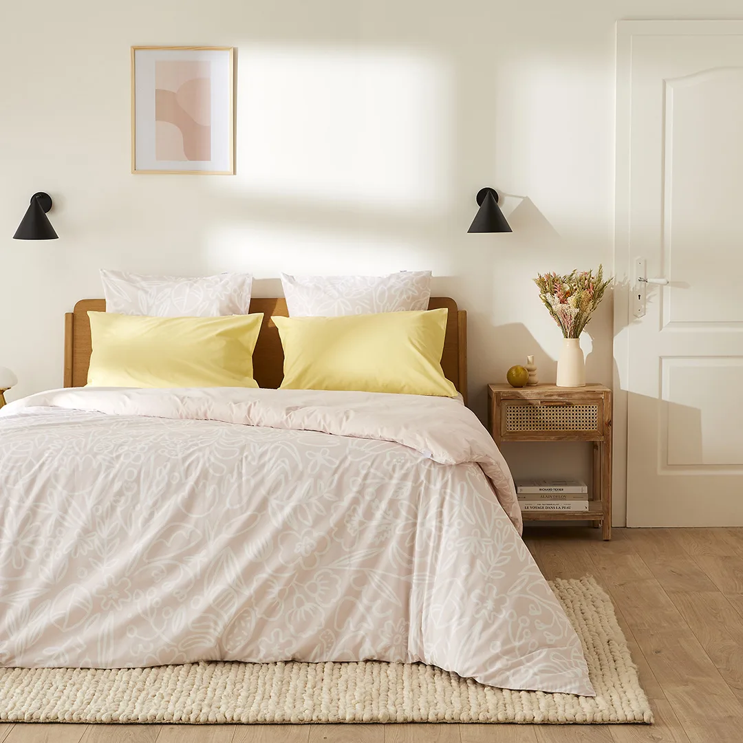 Chambre claire avec parure Flowrette et coussins jaunes, appliques noires.