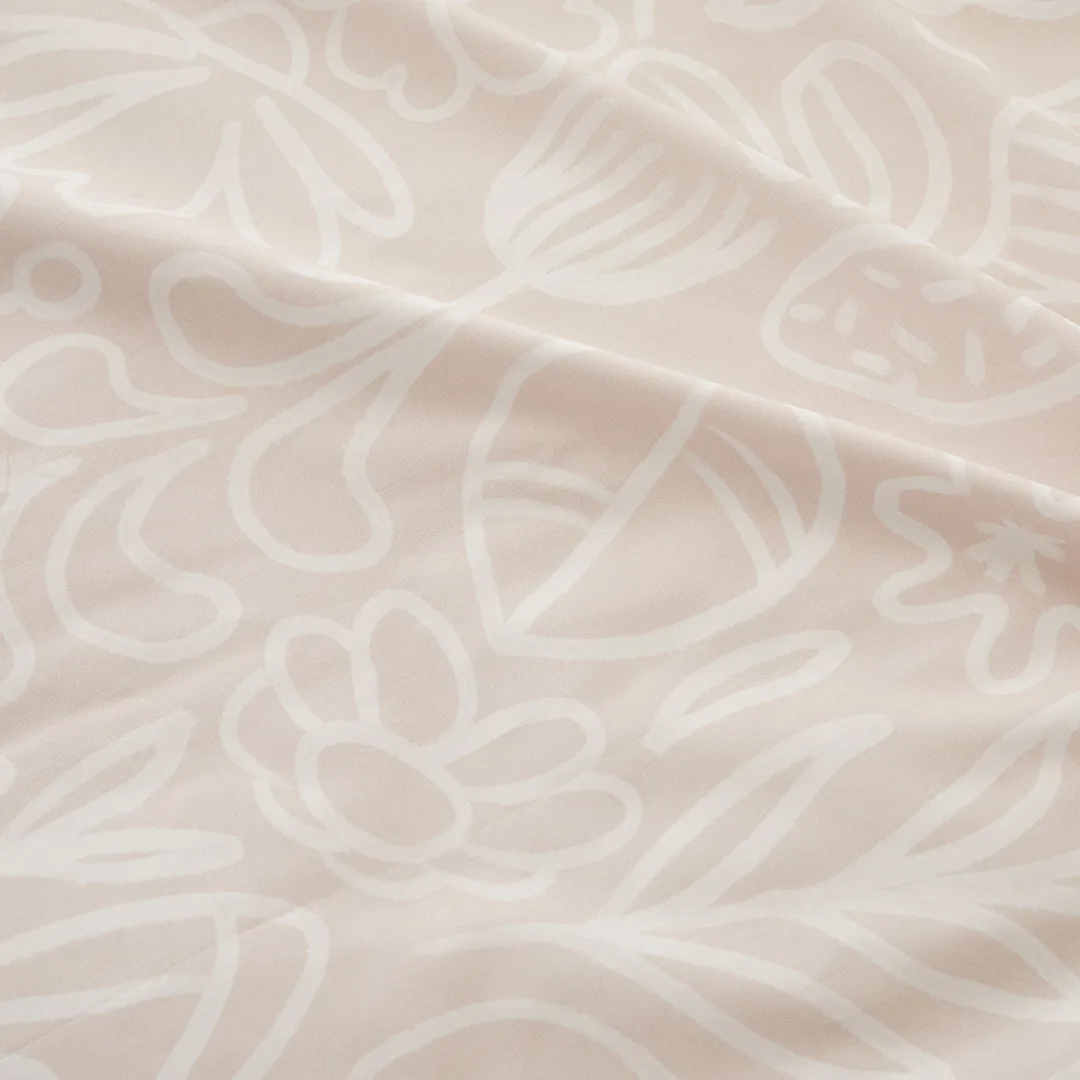 Gros plan du tissu : fleurs dessinées au trait, ton sur ton.